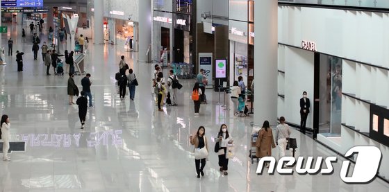 仁川国際空港の免税店を行き来する旅行客(c)news1