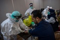インドネシアのスラバヤで、男性の血液サンプルを採取する医療従事者（2020年5月11日撮影）。(c)Juni Kriswanto / AFP