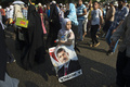 エジプト・カイロ（Cairo）で、ムハンマド・モルシ（Mohamed Morsi）前大統領の写真を片手にデモ行進に参加する少女（2013年8月12日撮影）(c)AFP/KHALED DESOUKI