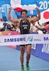 第17回アジア競技大会（17th Asian Games、Asiad）トライアスロンの混合リレーで、国旗を手にゴールラインを切る細田雄一（Yuichi Hosoda、2014年9月26日撮影）。(c)AFP/JUNG YEON-JE
