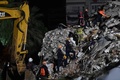 トルコ・イズミルで、倒壊した建物のがれきから生存者を捜索する救助隊員ら（2020年10月31日撮影）。(c)OZAN KOSE / AFP