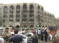 車両を使った自爆攻撃を受けて燃え上がるイラクの首都バグダッド（Baghdad）中心部の法務省庁舎前に集まった警官と軍兵士ら（2009年10月25日撮影）。(c)AFP/KHALIL AL-MURSHIDI