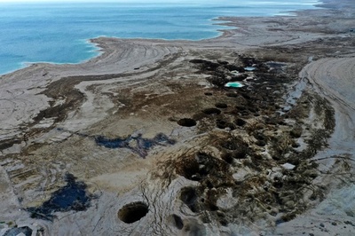 縮小する死海と湖岸に広がる陥没穴