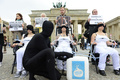 ドイツ・ベルリン（Berlin）のブランデンブルク門（Brandenburg Gate）の前で、搾乳機を胸に付けて酪農業界に対する抗議デモを行う国際動物愛護団体「動物の倫理的扱いを求める人々の会（PETA）」の活動家ら（2013年6月4日撮影）。(c)AFP/JOHN MACDOUGALL