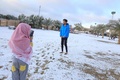 イラクの聖地カルバラで、雪の積もった公園内で写真を撮る人々（2020年2月11日撮影）。(c)Mohammed SAWAF / AFP