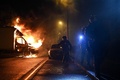 仏西部ナントで、炎上するトラックのそばを歩く警察官（2023年7月1日撮影）。(c)Sebastien SALOM-GOMIS / AFP