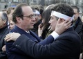 仏首都パリ（Paris）でテロに反対するため行われたデモ行進で、フランソワ・オランド（Francois Hollande）仏大統領（左）と抱き合う風刺週刊紙シャルリー・エブド（Charlie Hebdo）のコラムニスト、パトリック・プル―（Patrick Pelloux）氏（2015年1月11日撮影）。(c)AFP/PHILIPPE WOJAZER