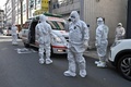韓国・大邱にある新興宗教団体「新天地イエス教会」支部付近で、新型コロナウイルス感染症の疑いのある住民を訪ねる医療従事者ら（2020年2月27日撮影）。(c)Jung Yeon-je / AFP