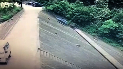自動車がダムの堤防を100メートル滑落、車上の二人は安全ベルトで無事 中国・浙江省