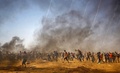 パレスチナ自治区ガザ地区のイスラエルとの境界付近で行われたデモで、催涙ガスから逃げるパレスチナ人（2018年6月8日撮影）。(c)AFP PHOTO / Mohammed ABED