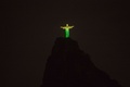 ブラジル・リオデジャネイロ（Rio de Janeiro）のコルコバード（Corcovado）の丘に立つ、ブラジル国旗の色に染め上げられた巨大なキリスト像（Christ the Redeemer、2014年6月11日撮影）。(c)AFP/YASUYOSHI CHIBA