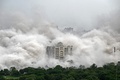 インド・ニューデリー郊外のノイダで爆破解体された超高層住宅「ツインタワーズ」の粉じんに包まれる近隣のビル（2022年8月28日撮影）。(c)Sajjad HUSSAIN / AFP