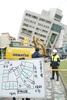 台湾東部・花蓮で、地震により傾いたビルの周辺の道路を封鎖する救助隊（2018年2月7日撮影）。(c)AFP PHOTO / PAUL YANG