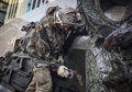 ロシアの首都モスクワ中心部で、自動小銃「AK47」の設計者、故ミハイル・カラシニコフ氏の像からナチス・ドイツの突撃銃「StG44」の図だと指摘された部分をアングルグラインダーで削る男性（2017年9月22日撮影）。(c)AFP/Mladen ANTONOV