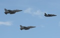 フィリピン・パンパンガ州のクラーク空軍基地で、同国の訓練用機（右）と編隊飛行する韓国製戦闘機「FA-50」2機（左および中央、2015年11月28日撮影）。(c)AFP/TED ALJIBE
