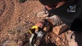 シリア北部の町アインアルアラブ（Ain al-Arab、クルド名：コバニ、Kobane）近郊で武器が入った木箱の中身を見せるイスラム過激派組織「イスラム国（Islamic State、IS）」の戦闘員を撮影したとされる動画のひとこま。イスラム国制圧地域からの映像を投稿するユーチューブ（YouTube）チャンネル「Aamaq News」より（2014年10月21日公開）。(c)AFP/HO/AAMAQ NEWS