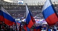 ロシア首都モスクワのルジニキ・スタジアムで、同国国旗を掲げる観客（2022年3月18日撮影）。(c)Yevgeny BIYATOV / POOL / AFP