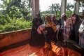 バングラデシュのコックスバザール地区にある学校で、ロヒンギャ難民の遺体を運ぶ女性（2017年9月29日撮影）。(c)AFP/FRED DUFOUR