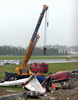 2007年9月17日、プーケット国際空港で着陸に失敗し炎上したタイ航空会社ワンツーゴー（One-Two-Go）旅客機の尾翼部分を重機で移動させる作業員たち。(c)AFP