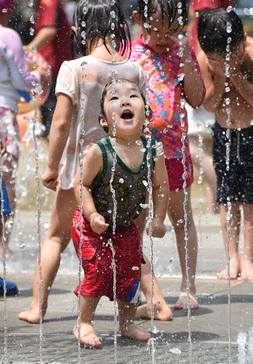公園の噴水で涼む子どもたち、東京