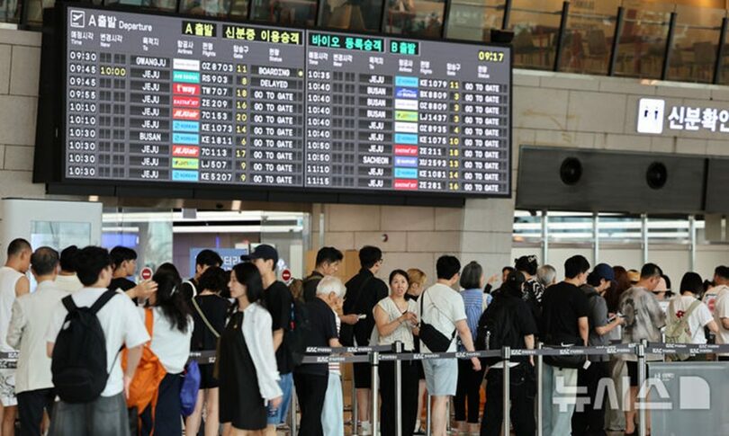 夏休みシーズンの金浦国際空港で搭乗手続きをする利用客(c)NEWSIS