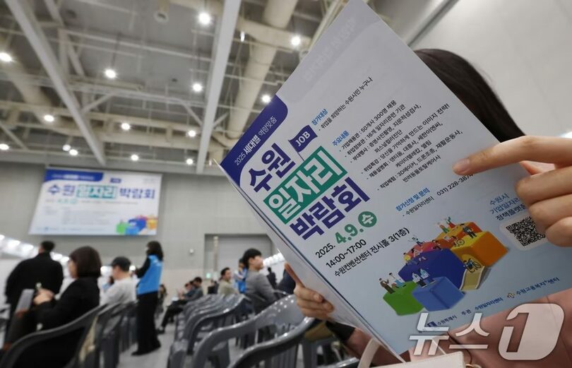 求人博覧会で案内文を読む求職者(c)news1