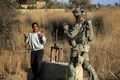 2008年3月8日、イラク・バグダッド（Baghdad）北東のディヤラ（Diyala）州で巡回する米兵と手をあげる少年。(c)AFP/DAVID FURST