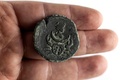 イスラエル考古学庁が公開した約1900年前のローマ時代の硬貨（2022年7月26日撮影）。(c)MENAHEM KAHANA / AFP