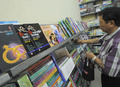 ミャンマー・ヤンゴン（Yangon）で、性教育雑誌「Hyno」を販売する書店で、本棚を見る客の男性（2013年1月5日撮影）。(c)AFP/Soe Than WIN