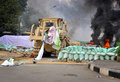 エジプト・カイロ（Cairo）で軍に解任されたムハンマド・モルシ（Mohamed Morsi）前大統領の支持者らが続けていた座り込みの抗議デモは14日、治安部隊が強制排除に乗り出し、多数の死者を出す流血の惨事となった。エジプト各地でもムスリム同胞団（Muslim Brotherhood）と治安部隊が衝突。エジプト保健省は15日、全国で少なくとも464人が死亡したと発表した。うち421人が民間人という。

治安部隊はモルシ氏支持派が座り込みを続けていたカイロ東部のラバ・アルアダウィヤ（Rabaa al-Adawiya）モスク近くの広場と、中心部のナハダ（Nahda）広場の2か所に、夜明けとともにブルドーザーを従えて突入。軍はかねて、座り込みを止めなければ強制的に排除すると警告していた。保健省によると、各地の死者数はラバ・アルアダウィヤモスク付近で137人、ナハダ広場では57人、その他全国各地で227人となっている。

写真はナハダ広場で、デモ隊が築いたバリケードを突破するブルドーザー（2013年8月14日撮影）。(c)AFP/ENGY IMAD