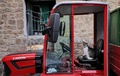 イスラエル北部アッコで、小型トラクターの運転席に座る猫（右）と、ボンネットで休む猫（2021年4月26日撮影）。(c)Emmanuel DUNAND / AFP