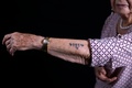 腕に入れられたアウシュビッツ囚人番号を見せるホロコーストの生存者バットシェバ・ダガンさん（2019年12月25日撮影）。(c)MENAHEM KAHANA / AFP