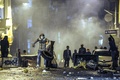 トルコ・イスタンブール（Istanbul）で、機動隊とにらみ会うクルド人のデモ参加者たち（2014年10月8日撮影）。(c)AFP/OZAN KOSE