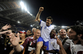 元フランス代表でASローマ（%%AS Roma%%）などで活躍したヴァンサン・カンデラ（%%Vincent Candela%%）氏の引退記念試合（ASローマ2001対フランス1998）が5日、ローマ（Rome）のスタディオ・オリンピコ（Stadio Olimpico）で行われた。写真は試合後にダニエレ・デ・ロッシ（%%Daniele De Rossi%%、左）やアウダイール（%%Aldair%%、右）に抱えられ笑顔を見せるヴァンサン・カンデラ氏。（2009年6月5日撮影）(c)AFP/FILIPPO MONTEFORTE