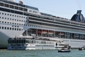 イタリアのベネチアで、損傷を負った観光船（前方左）と大型クルーズ船MSCオペラと船上から見守る観光客（2019年6月2日撮影）。(c)Andrea PATTARO / AFP