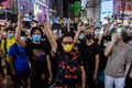 香港・銅鑼湾地区で行われた抗議デモで、歌いながらライトを点灯したスマートフォンを掲げる参加者ら（2020年6月12日撮影）。(c)Anthony WALLACE / AFP