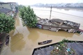 洪水により家屋が浸水した中国・浙江省（Zhejiang）杭州（Hangzhou）で、ボートで移動する住民（2008年6月18日撮影）。(c)AFP