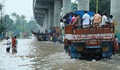 インド南部ケララ州コーチで、冠水した道路をトラックに乗って避難する人々（2018年8月16日撮影）。(c)AFP