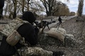ウクライナの首都キエフ東郊のブロバルイ近郊で、ロシア軍の陣地に向け銃を構えるウクライナ兵（2022年3月9日撮影）。(c)Aris Messinis / AFP