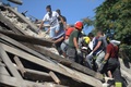 イタリア・ペスカーラデルトロントで、地震の犠牲者の遺体を搬送する救助隊（2016年8月24日撮影）。(c)AFP/MARCO ZEPPETELLA