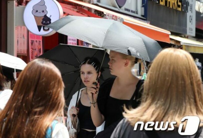 ソウル・明洞の通りで日傘をさして歩く外国人(c)news1