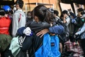 香港理工大学の構内から脱出するため、歩道橋から幹線道路へロープで下りる前に、抱き合うデモ参加者（2019年11月18日撮影）。(c)AFP/Anthony WALLACE
