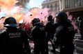 スペイン北東部カタルーニャ自治州のバルセロナで、中央政府の警官に支持を示す集会への対抗デモの際、地元警官に塗料やカラーパウダーを投げる参加者（2018年9月29日撮影）。(c)Pau Barrena / AFP