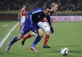 2010年サッカーW杯南アフリカ大会（%%2010 World Cup%%）1次リーグE組、デンマーク対日本。日本は3-1で勝利し、勝ち点6（2勝1敗）の同組2位で決勝トーナメントに進んだ。日本の決勝トーナメント進出は、自国開催以外のW杯では初めて。写真はデンマークのトマス・カフレンベルグ（%%Thomas Kahlenberg%%）と競り合う日本の田中マルクス闘莉王（%%Marcus Tulio Tanaka%%、左）。（2010年6月24日撮影）(c)AFP/STEPHANE DE SAKUTIN