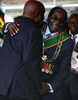 ジンバブエの首都ハラレ（Harare）で22日、先の大統領選挙で再選したロバート・ムガベ（Robert Mugabe）大統領（89）の就任宣誓式が行われ、会場となった6万人収容の競技場はムガベ氏の支持者で埋め尽くされた。ムガベ大統領の新たな任期は5年。

写真は就任宣誓式で、ザンビアのケネス・カウンダ（Kenneth Kaunda）元大統領から祝福されるムガベ大統領（2013年8月22日撮影）。(c)AFP/ALEXANDER JOE
