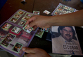 コロンビア・メデジン（Medellin）の貧困地区で、麻薬王パブロ・エスコバル（Pablo Escobar）のシールをシールブックに貼る少年（2012年8月8日撮影）。(c)AFP/Raul ARBOLEDA