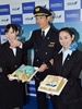 国際線の発着枠が拡大された羽田空港（Haneda Airport）で、全日空（All Nippon Airways、ANA）の羽田-ハノイ（Hanoi）線の新規開設を祝って作られたケーキを披露する同社のパイロットと客室乗務員ら（2014年3月30日撮影）。(c)AFP/Yoshikazu TSUNO