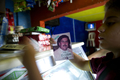 コロンビア・メデジン（Medellin）の貧困地区で、麻薬王パブロ・エスコバル（Pablo Escobar）のシールブックを手にする少年（2012年8月8日撮影）。(c)AFP/Raul ARBOLEDA