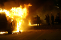 ギリシャの首都アテネ（Athens）で、炎上する車両の消火活動を行う消防隊員（2008年12月9日撮影）。(c)AFP