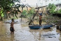 台風16号が通過したフィリピン・リサール州サンマテオの浸水地域で舟に乗る人（2022年9月26日撮影）。(c)JAM STA ROSA / AFP